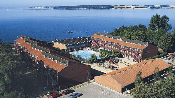 Un immeuble doté d’une piscine, d’un parking et offrant une vue sur la mer.