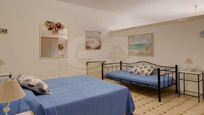 Un dormitorio con dos camas, un espejo y obras de arte en las paredes.
