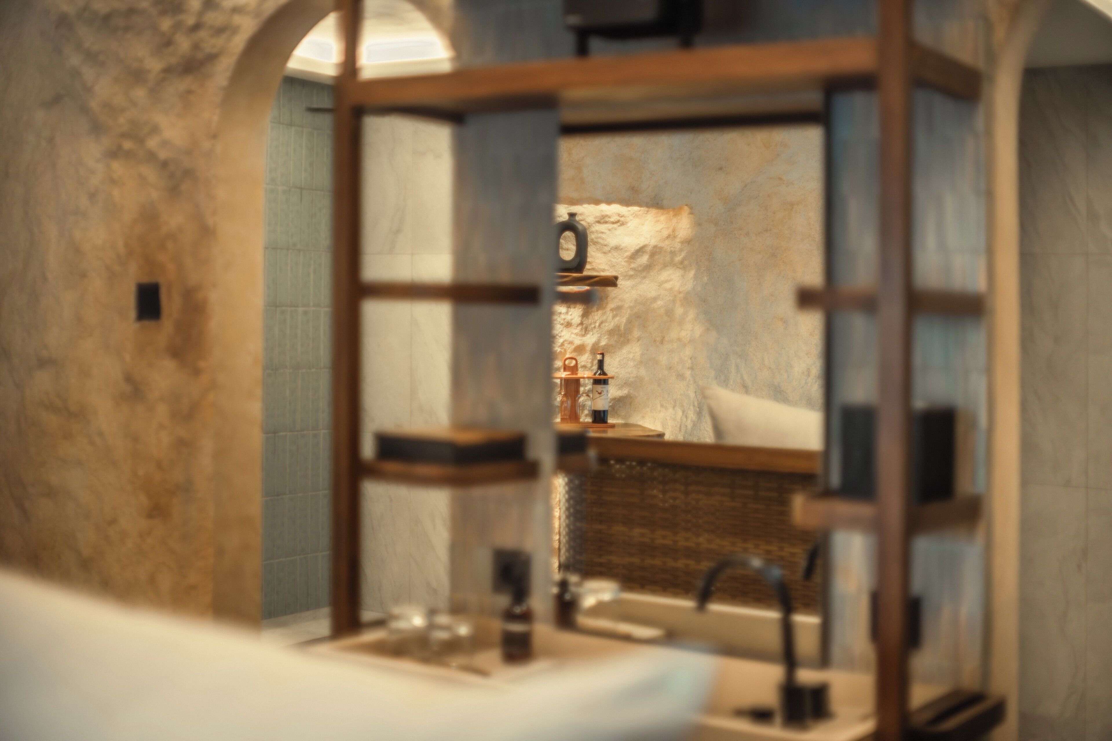 Une salle de bain avec un mur en marbre, un lavabo, un miroir et un porte-serviettes.