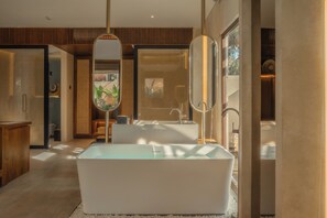 A modern bathroom with a freestanding bathtub, a large mirror, and a wooden vanity. - La Mewali Resort Canggu by Ini Vie Hospitality (Canggu)