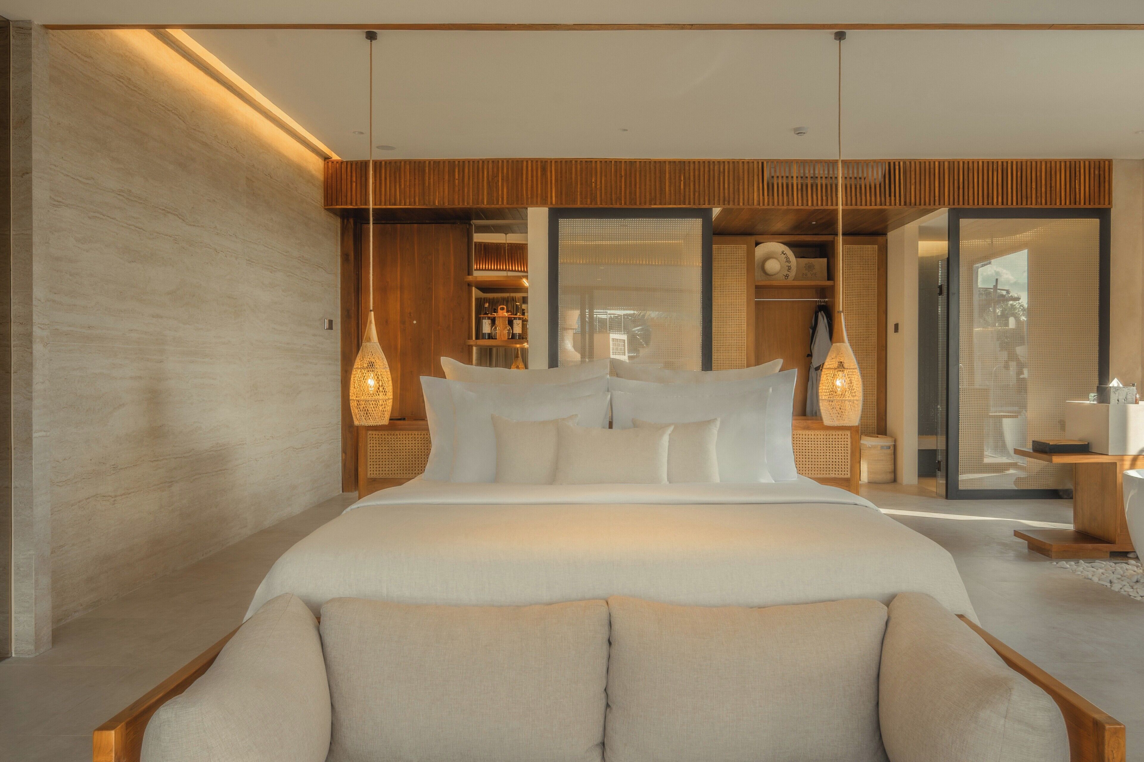 Ein modernes Schlafzimmer mit einem großen Bett, Holzwandverkleidung und Blick durch eine Glastür.