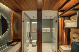 A modern bathroom with a wooden ceiling, a glass shower enclosure, a toilet, and a sink.