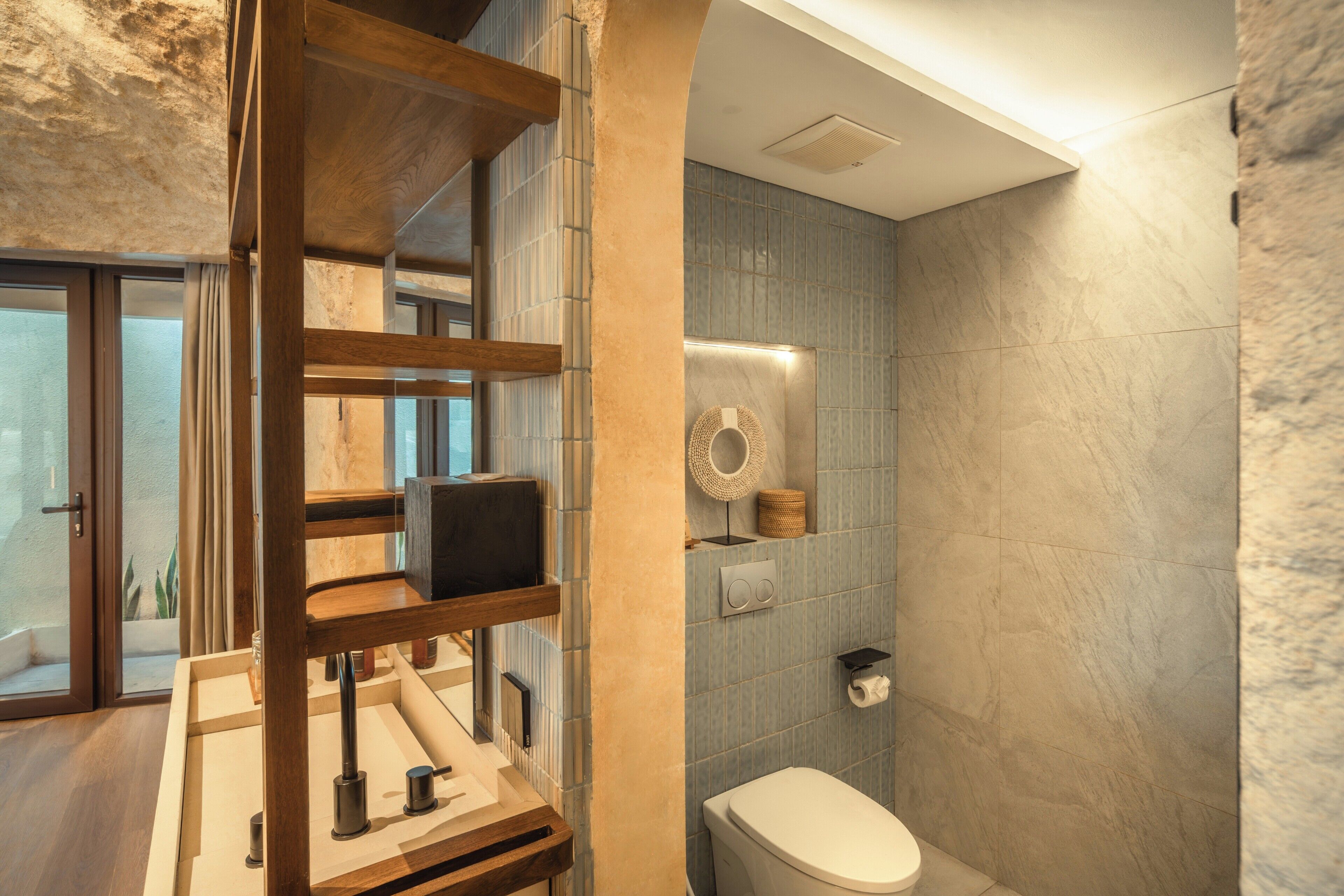 Un baño moderno con tocador de madera, inodoro y zona de ducha.