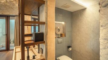 Un baño moderno con tocador de madera, inodoro y zona de ducha.