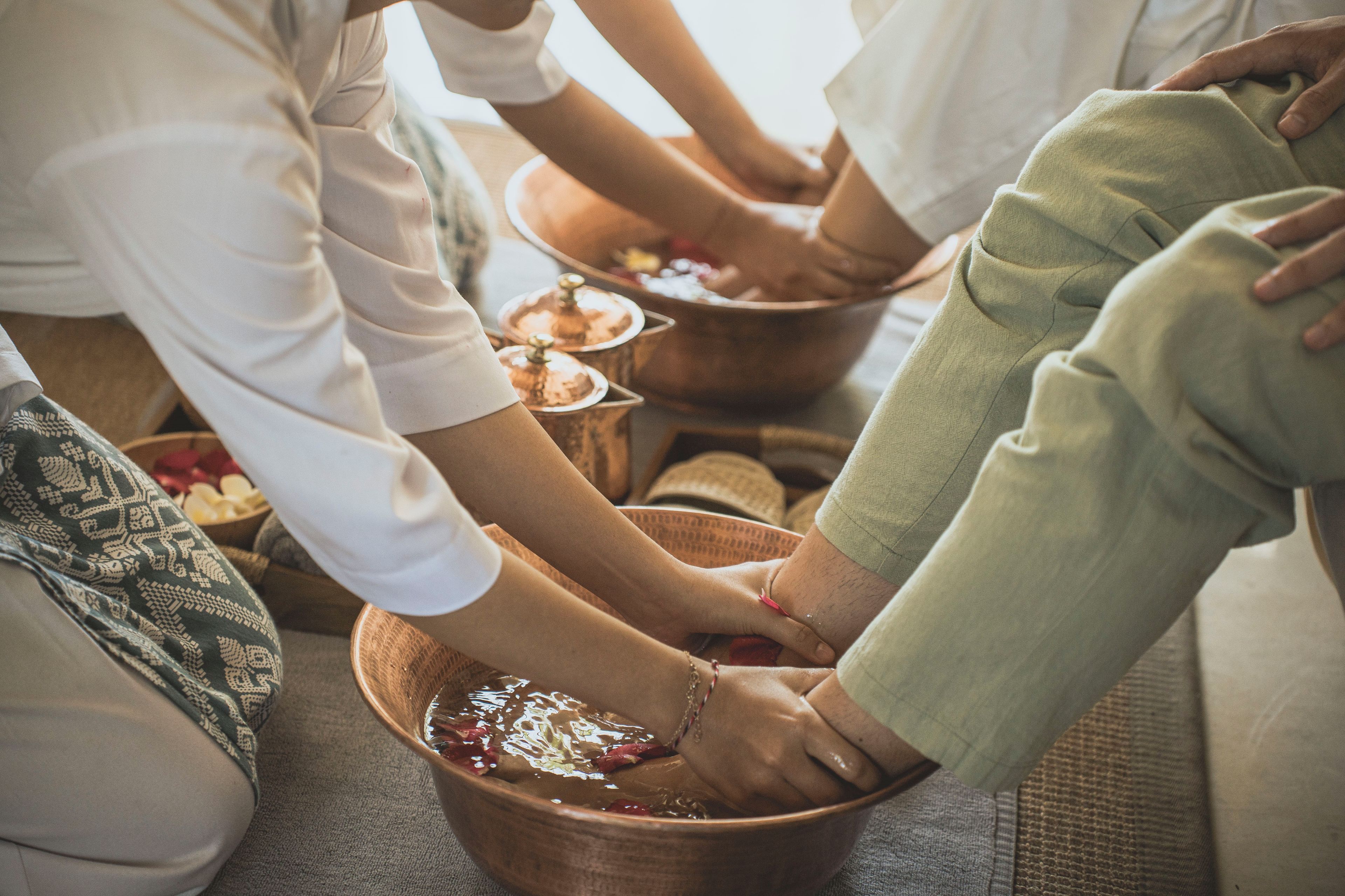 A group of people sitting on the floor, participating in a communal activity with bowls in front of them.