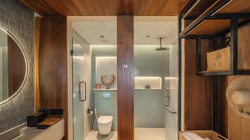 Un baño moderno con techo de madera, cabina de ducha de vidrio y inodoro a la vista.