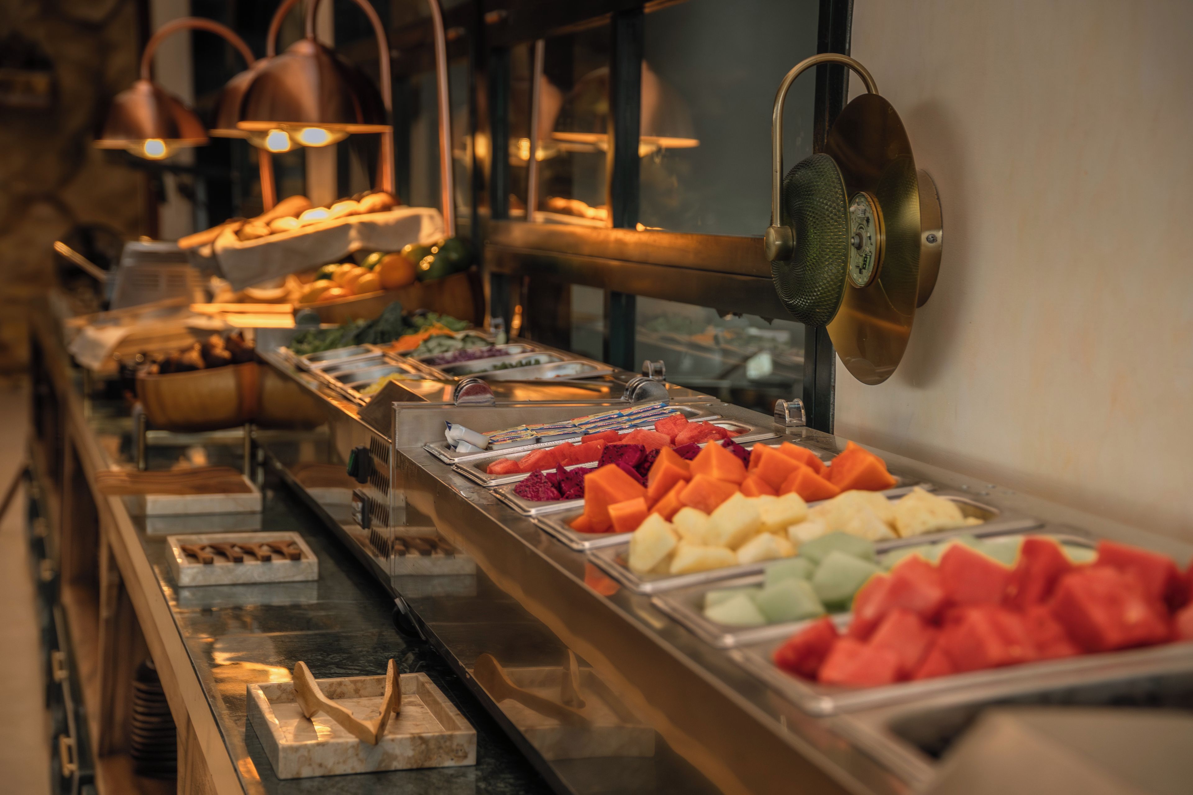 A buffet with various food items and a water dispenser.