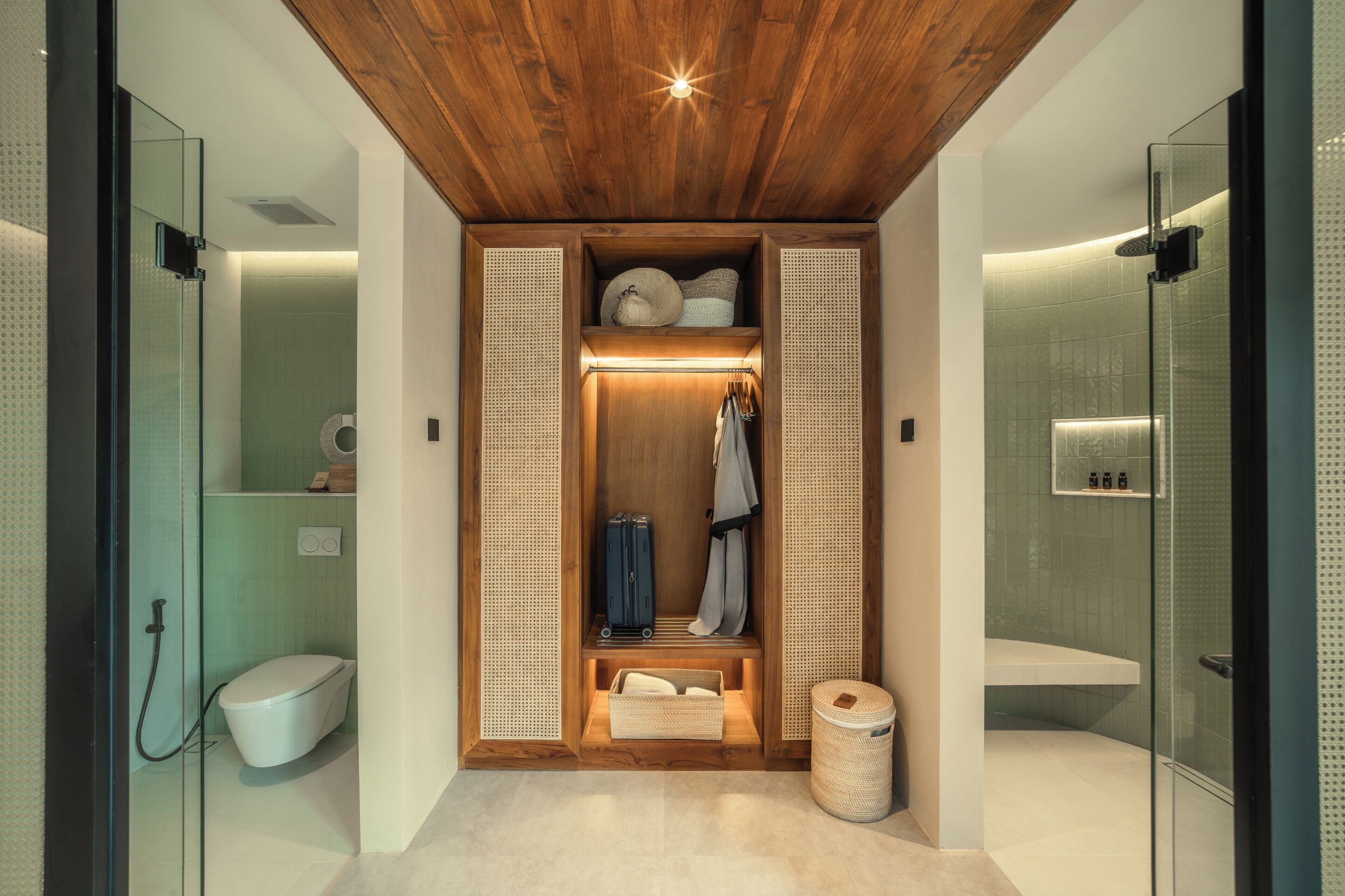 A modern bathroom with a glass shower enclosure, a wooden ceiling, and a built-in storage unit with shelves and hanging space.