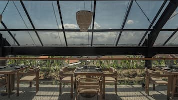 Ein Restaurant mit großer Glasüberdachung, Außenbereich und Blick auf die Landschaft.