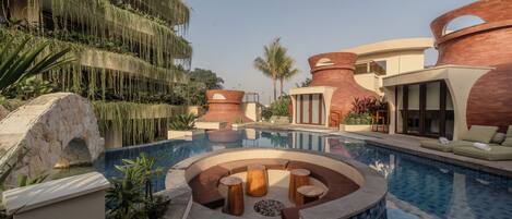 A pool area with a circular seating arrangement and a stone structure.