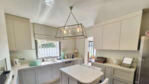 Una cocina moderna con una isla central, una ventana y una lámpara colgante.