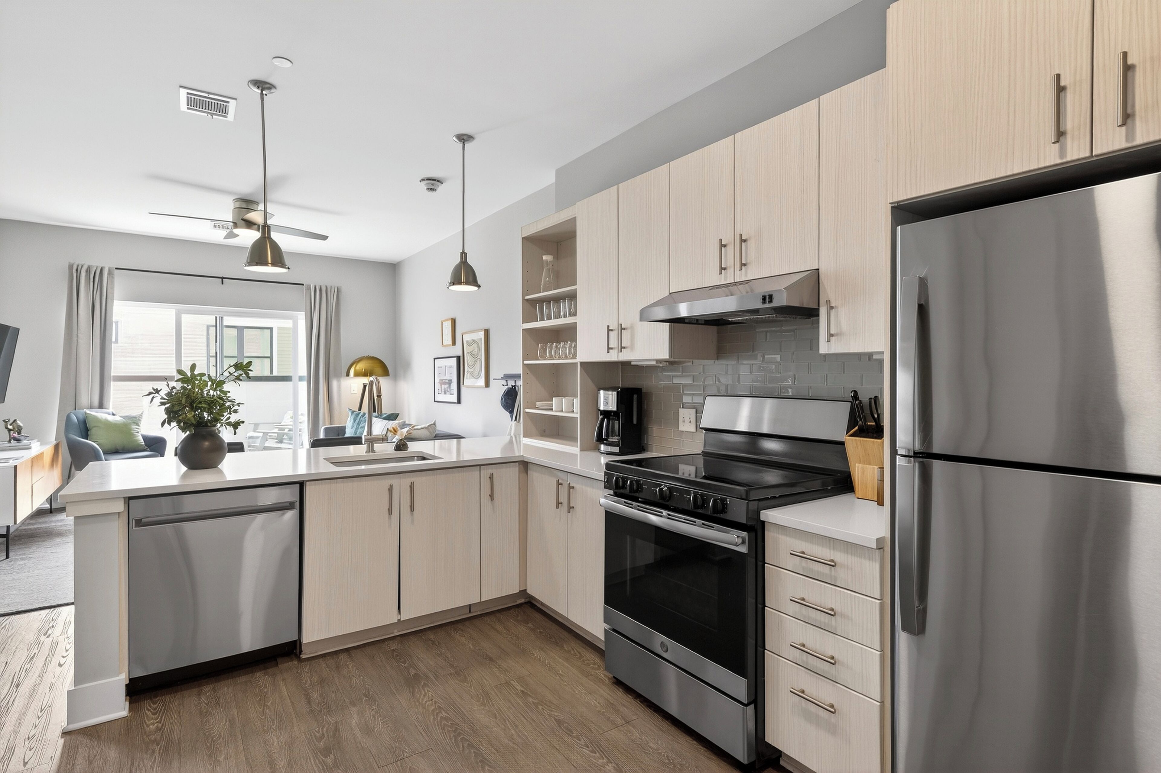 A modern kitchen with stainless steel appliances, wooden cabinets, and a built-in oven.