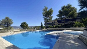 Une piscine offrant une vue dégagée sur les environs, notamment sur un bâtiment et des arbres.