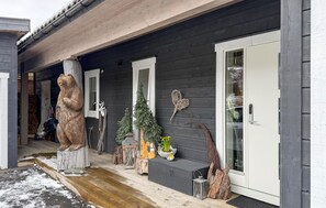 A wooden house with a porch, a bear sculpture, a Christmas tree, and a door with a glass panel. - Awesome home in Stryn with house a mountain view (Stryn)