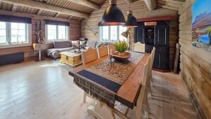 A log cabin interior with a dining area, wooden furniture, and a large window. - Amazing home in Ustaoset (Ustaoset)