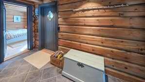 A log cabin interior with a bed, a door with a diamond-shaped window, and a chest of drawers. - Amazing home in Ustaoset (Ustaoset)