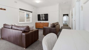 Una sala de estar moderna con un sofá, una mesita y un televisor.