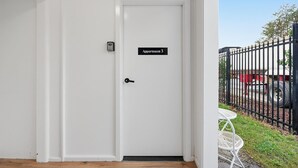 Una porta bianca con una targa che riporta 'Apartment 3' e una serratura.