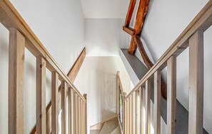 A staircase with wooden railings and a handrail, leading to a landing with a white wall and a wooden beam. - 2 bedroom cozy home in Saigneville (Saigneville)