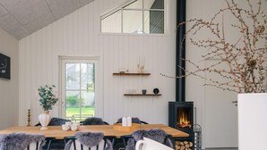 Un coin repas avec une table en bois, des chaises et une cheminée.