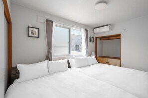 A hotel room with a large bed, a wardrobe, a window with curtains, and a ceiling light. - ASAHIKAWA STAY ECOLE 101  (Asahikawa)