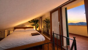 A bedroom with a bed, a plant, and a view of the sky. - La Terrazza a Rio Elba (Rio dell'Elba)