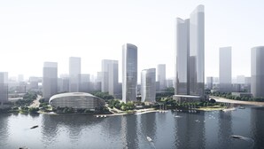 Eine moderne Skyline mit hohen Gebäuden, einer Uferpromenade und einem markanten kreisförmigen Bauwerk.