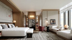 Ein modernes Hotelzimmer mit einem großen Bett, einer Couch, einem Esstisch und Blick auf die Stadt.
