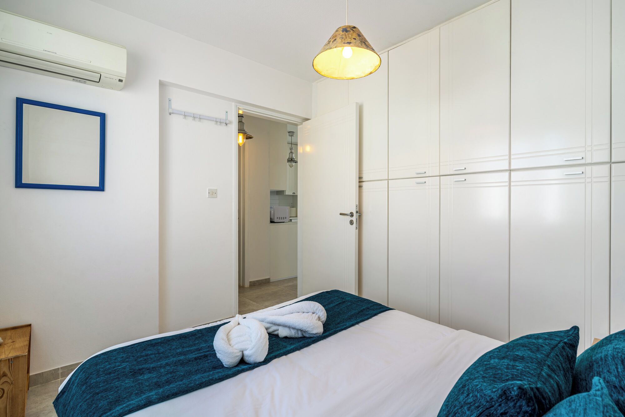Ein Hotelzimmer mit Bett, Schrank, Badezimmer und Flur.