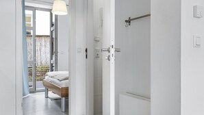 Une chambre d’hôtel moderne, équipée d’un lit, d’une salle de bain et offrant une vue sur l’extérieur.