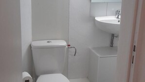 Un bagno piccolo e pulito con WC, lavandino e specchio.