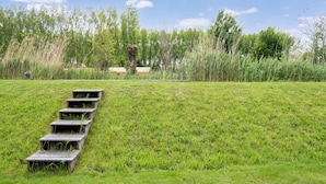 Un campo cubierto de hierba con escalones de madera que suben una pendiente.
