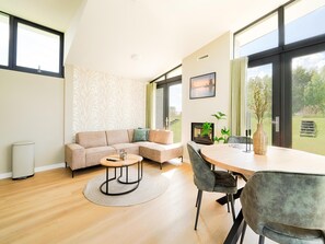 Un salon moderne avec un canapé, une table basse et un coin repas.