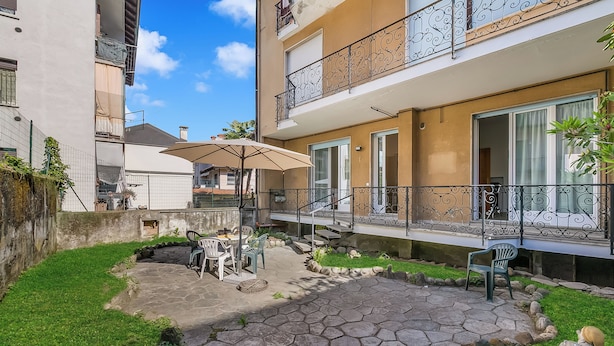 A courtyard with a patio, outdoor seating, and a small garden area. - Casa Adelina, Center Flat With Private Garden (Stresa)