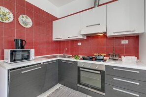 Eine Küche mit Mikrowelle, Backofen und Spüle.