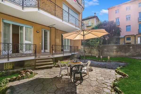 Une terrasse avec une table, des chaises et un parasol.