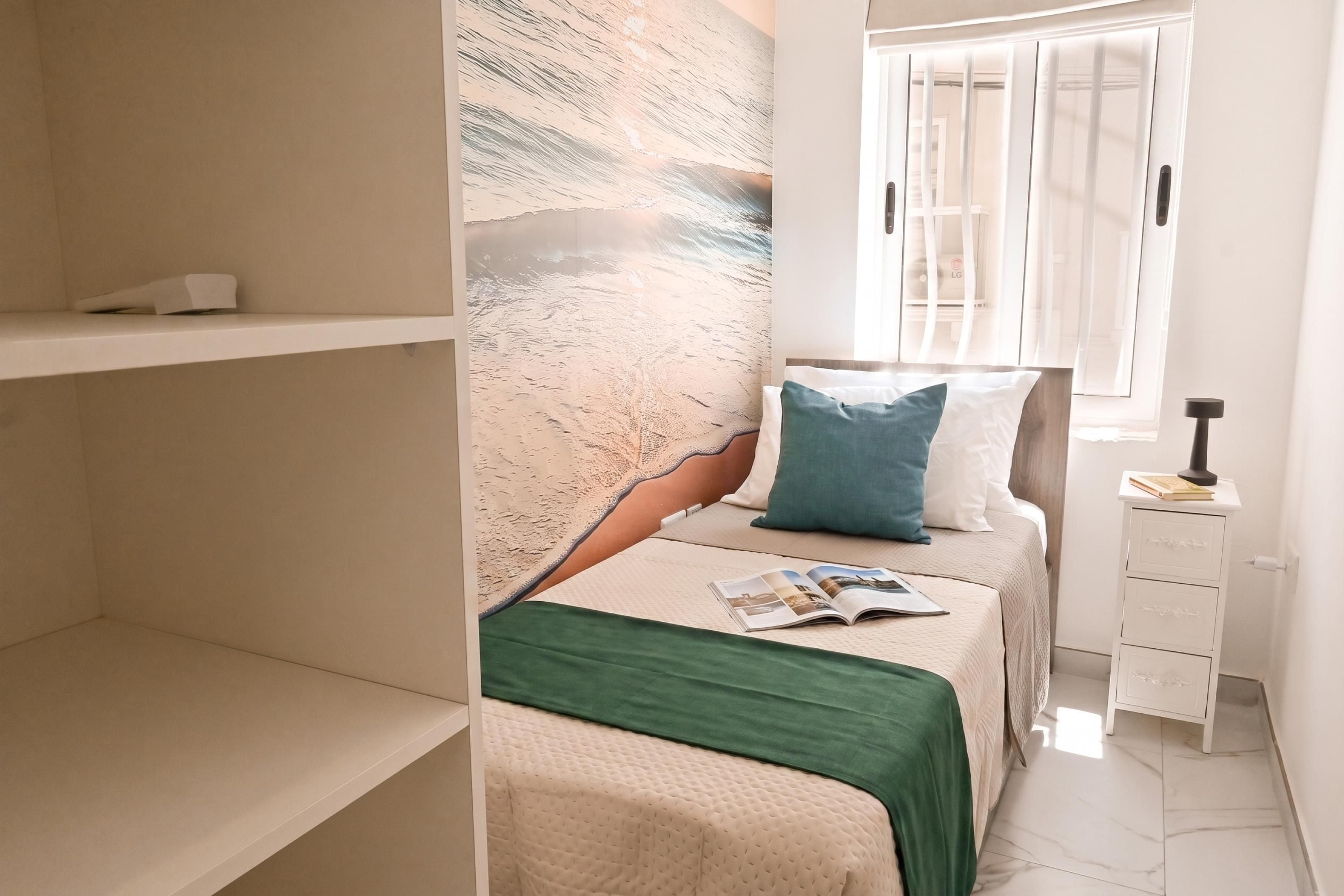 Un dormitorio con cama, una ventana con persianas, una mesita de noche y un cuadro con textura en la pared.