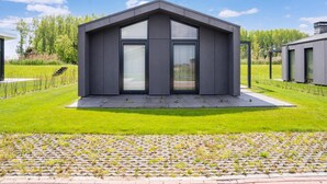 Ein modernes Haus mit Flachdach, großen Fenstern und einem gepflegten Rasen.