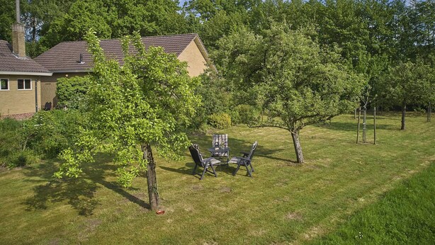 A residential property with a house, a lawn, and a small seating area with chairs and a table. - Rural holiday home with expansive views (Aalten)