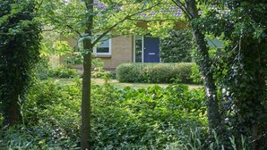 A residential building with a brick facade, a blue door, and a small window. - Rural holiday home with expansive views (Aalten)