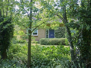 A residential building with a brick facade, a blue door, and a small window. - Rural holiday home with expansive views (Aalten)