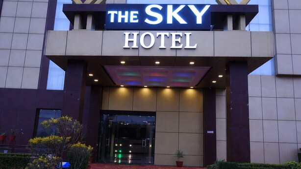 The Sky -hotellin ulkoasu: selkeä kyltti, lasinen sisäänkäynti ja punainen matto, joka johtaa oville.