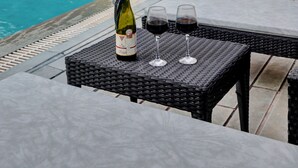 Ein Poolbereich mit Tisch, einer Flasche und Gläsern.