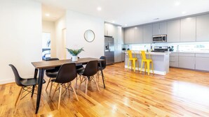 A modern kitchen with grey cabinets, a stainless steel refrigerator, and a microwave. - 111 Lavish Bungalow 1753! Medical Center, Stadiums (Houston)