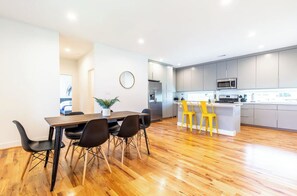 Une cuisine moderne avec des meubles gris, un réfrigérateur en acier inoxydable et un four à micro-ondes.