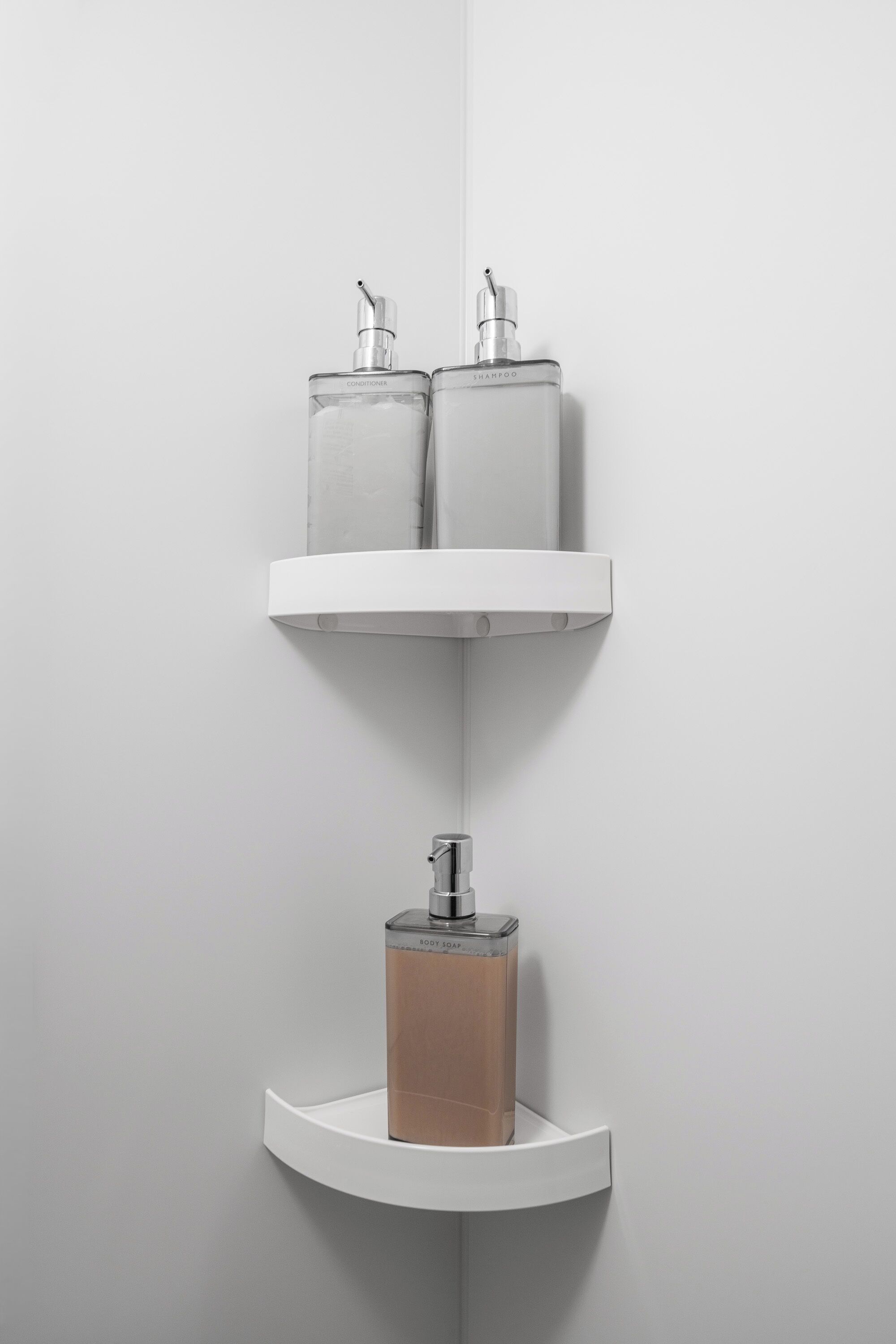 A bathroom with a white sink, two shelves with toiletry bottles, and a soap dispenser.