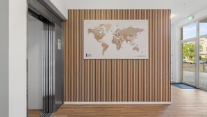 Un interior moderno con un panel de madera, un mapa del mundo y vistas al exterior.
