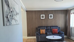Ein Wohnzimmer mit einer Couch, einem Couchtisch und einem gemusterten Teppich.
