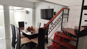 A dining area with a table, chairs, and a staircase with a red handrail. - Beautiful house in Cartago Valle (Cartago)