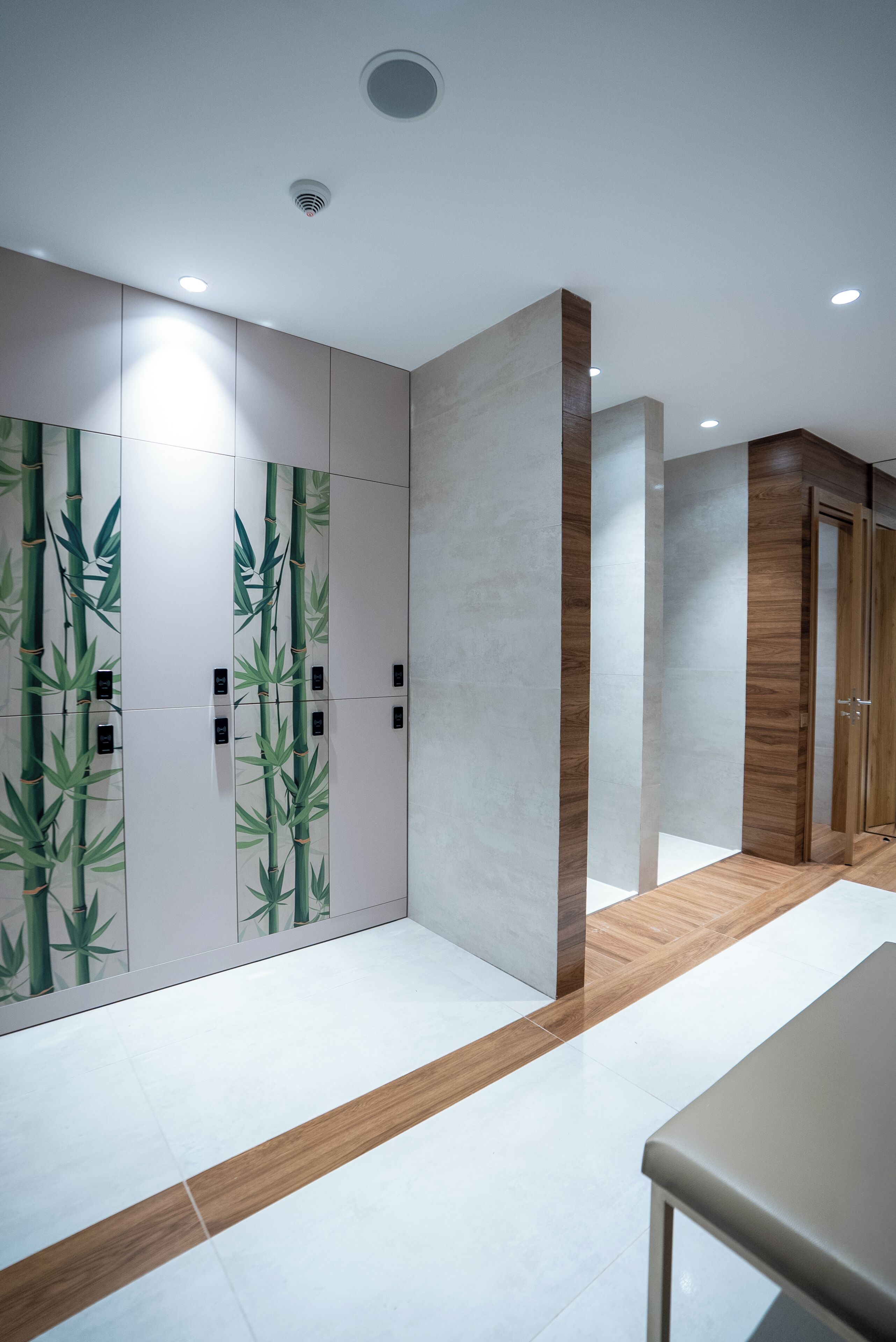 Un pasillo de diseño moderno, con paneles de madera y blanco, un muro con motivos de bambú y suelo de madera.